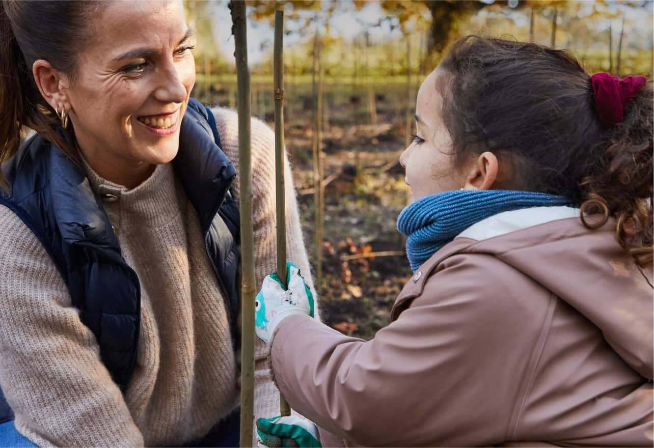 Mujer y niño plantando un árbol